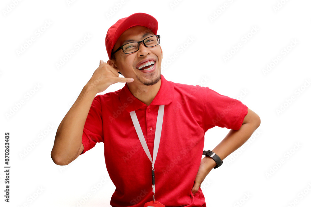 Asian delivery man or courier stands confidently against a white background, making a playful 'call me' gesture with his hand. Concepts of customer engagement, communication, and delivery services Asian delivery man or courier stands confidently against a white background, making a playful 'call me' gesture with his hand. Concepts of customer engagement, communication, and delivery services