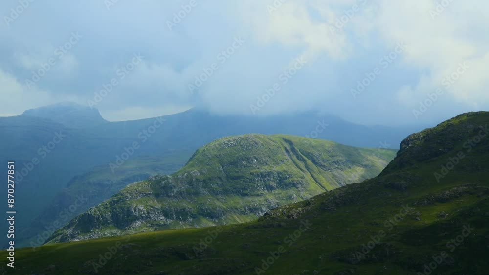 Thick clouds racing over covered mountaintop of Scafell with cloud shadows moving rapidly between valleys and over mountainous landscape. Timelapse 60x. English Lake District Park, Cumbria, UK Thick clouds racing over covered mountaintop of Scafell with cloud shadows moving rapidly between valleys and over mountainous landscape. Timelapse 60x. English Lake District Park, Cumbria, UK