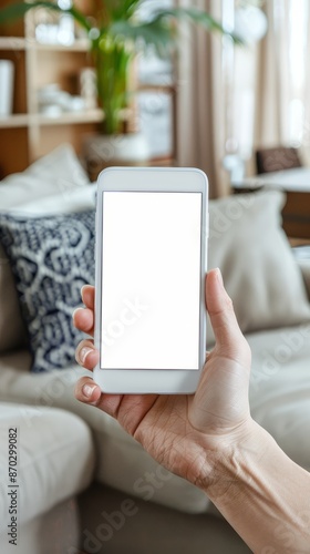 A hand holding a blank white smartphone with, accented on the screen