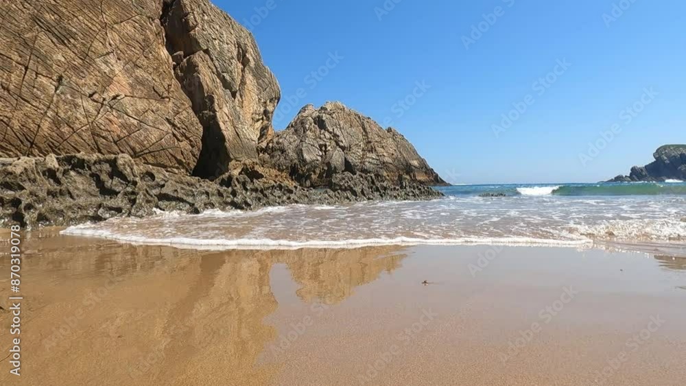 A beautiful view of a beach inside a big rock with the water of the sea A beautiful view of a beach inside a big rock with the water of the sea