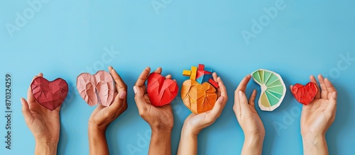 Copy space image featuring paper symbolic representations of liver, heart, eye, kidney, and lung held by human hands, illustrating the concept of organ donation & transplantation in healthcare.