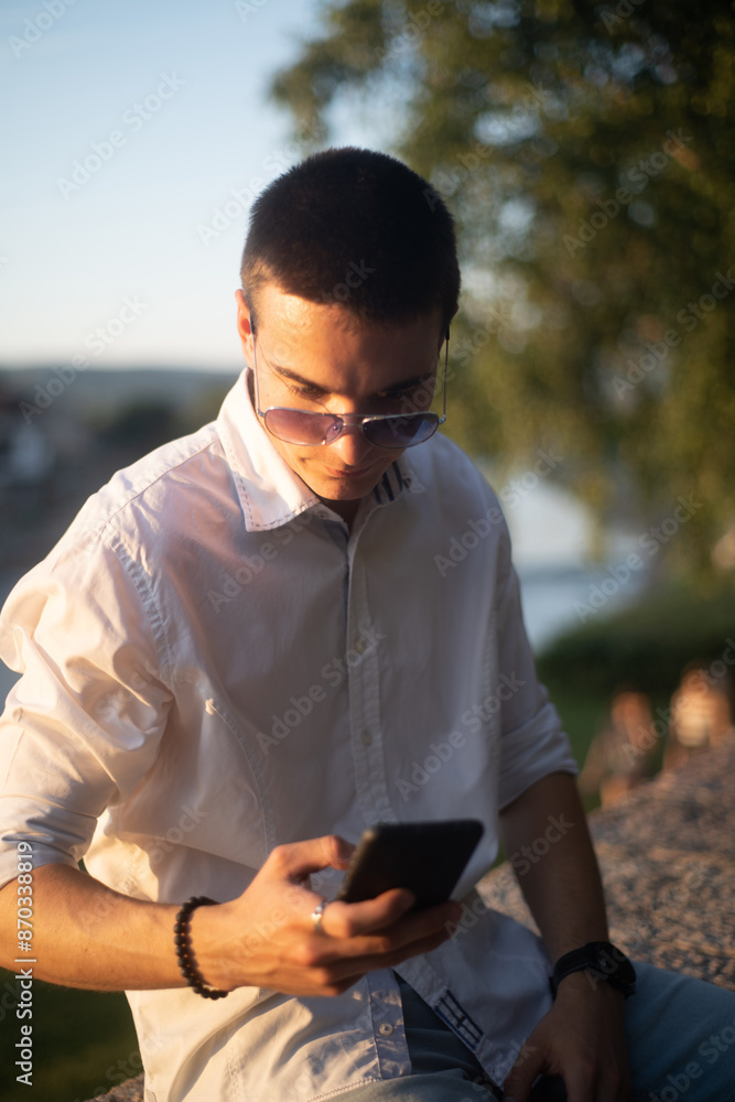Young man with sunglasses outdoor using phone Young man with sunglasses outdoor using phone