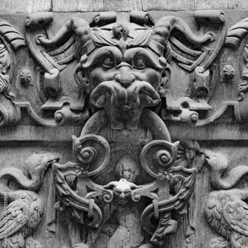 Détail d'une sculpture gothique en pierre avec visage démoniaque en noir et blanc