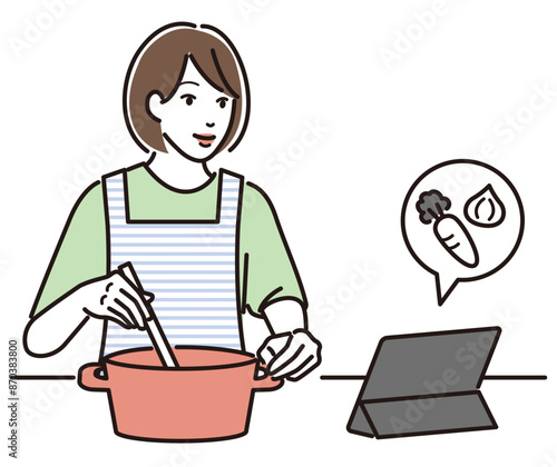 タブレットでレシピを見ながら料理する女性