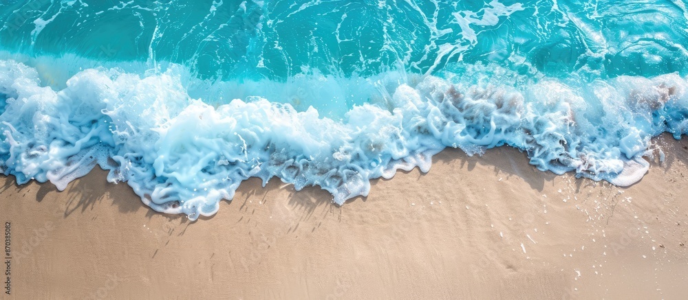 Turquoise ocean waves gently caressing a sandy beach, captured in a high-angle copy space image. Turquoise ocean waves gently caressing a sandy beach, captured in a high-angle copy space image.