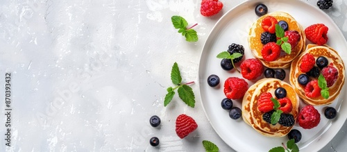 Delicious homemade pancakes with fresh berries on top in a photo with copy space image.