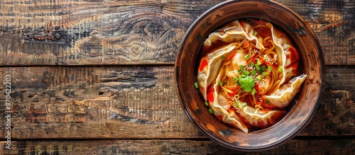 Delicious Japanese Gyoza with crispy outsides and soft pork filling, served in a flavorful soup, commonly eaten with soy sauce, showcased on a wooden backdrop with a top view and copy space image. photo