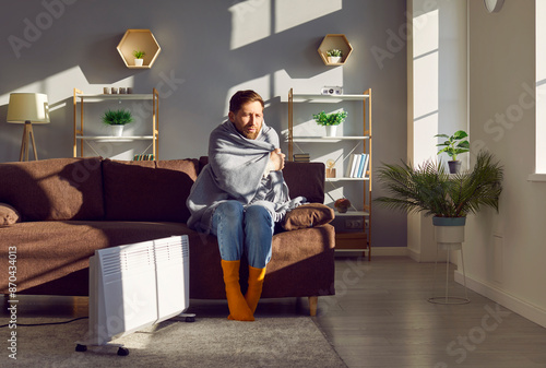 Картината върху платно Young man gets frozen inside his chilly apartment during a very cold winter season