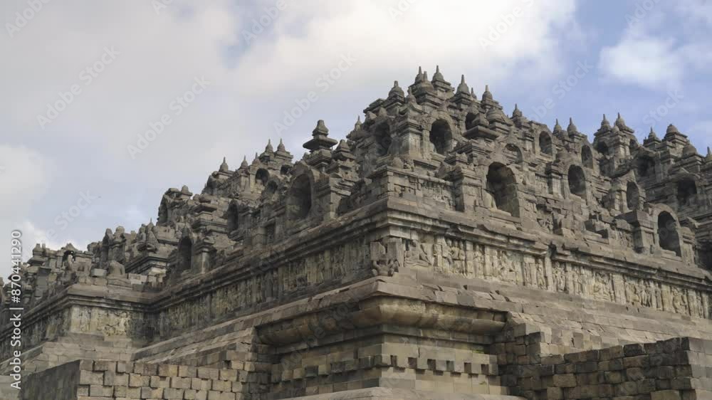 Close view on the famous Borobudur temple with its details and black walls statues in Yogyakarta Java Indonesia - panning shot on a bright day with greeneries Close view on the famous Borobudur temple with its details and black walls statues in Yogyakarta Java Indonesia - panning shot on a bright day with greeneries