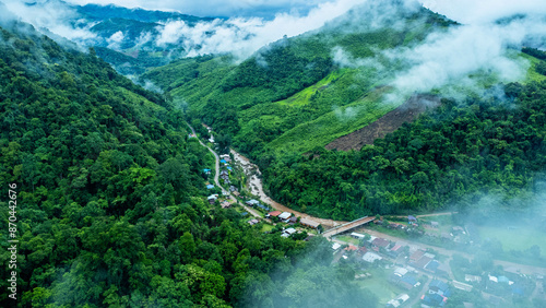 Aerial view of the beautiful Sapan village scenery, a small village in the middle of a valley surrounded by nature during the rainy season. photo