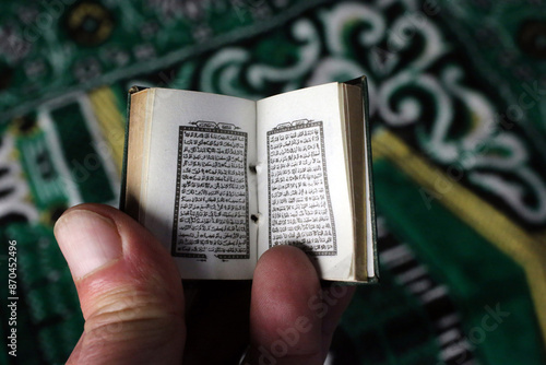 Man readind a mini Quran in mosque. photo