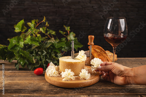 Woman slicing delicious tete de moine cheese photo