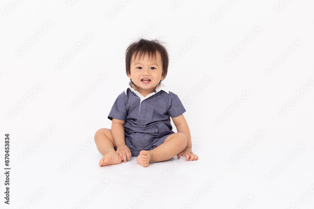 Smiling Toddler Sitting on Floor in Blue Outfit Smiling Toddler Sitting on Floor in Blue Outfit