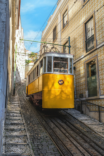 Famous vintage yellow tram  in the narrow streets of Alfama district in Lisbon, Portugal photo