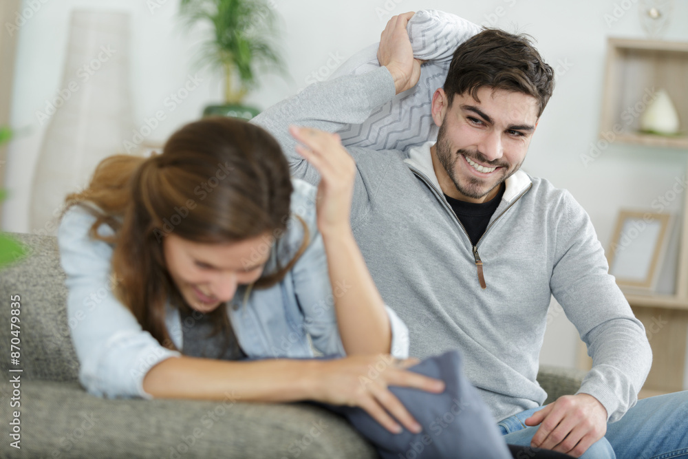 a happy couple is pillow fighting at home a happy couple is pillow fighting at home