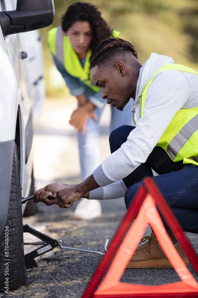 Obraz premium red triangle and couple near his brocken car
