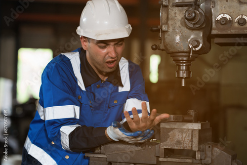 Factory male worker accident at his arms during working with lathe machine in industry factory photo