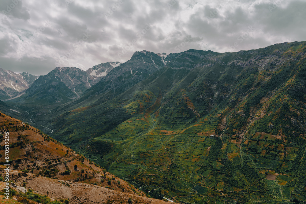 The mountains are covered in green vegetation and the sky is cloudy The mountains are covered in green vegetation and the sky is cloudy