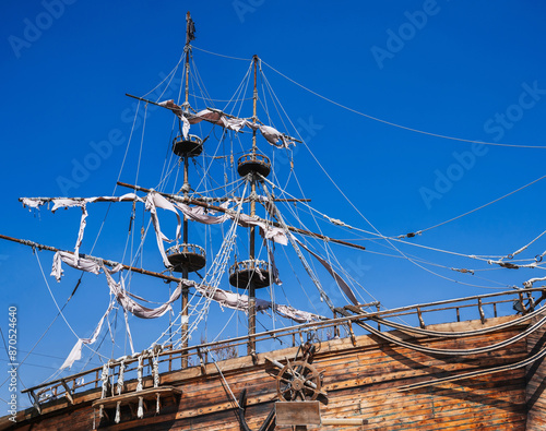 Fotografija mast with sails on an ancient wooden pirate ship on background of blue sky