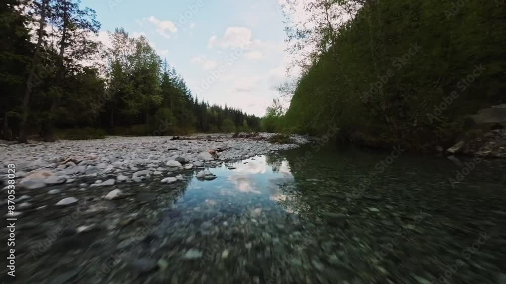 Low-altitude flight over a rocky river with abundant greenery on a bright sunny day near Stave Lake in Mission BC. Low-altitude flight over a rocky river with abundant greenery on a bright sunny day near Stave Lake in Mission BC.