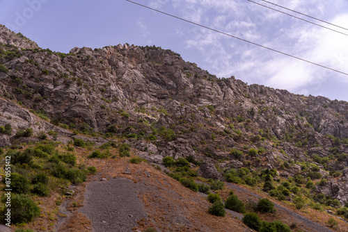 A mountain with a rocky terrain and a few trees