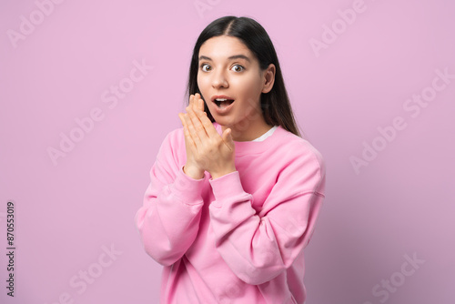 Whoa, didn't see that coming. Young woman in pink, eyes wide and jaw dropped, serving pure surprise vibes. Perfect for capturing those unexpected, OMG moments