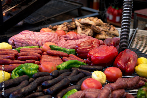 Street food in San Fermin feast, Pamlona, Navarra, Spain. Pork. Grilled meat with grilled vegetables and sausage. Spanish traditional cuisine. Spanish national dish. image toned and noise added. photo