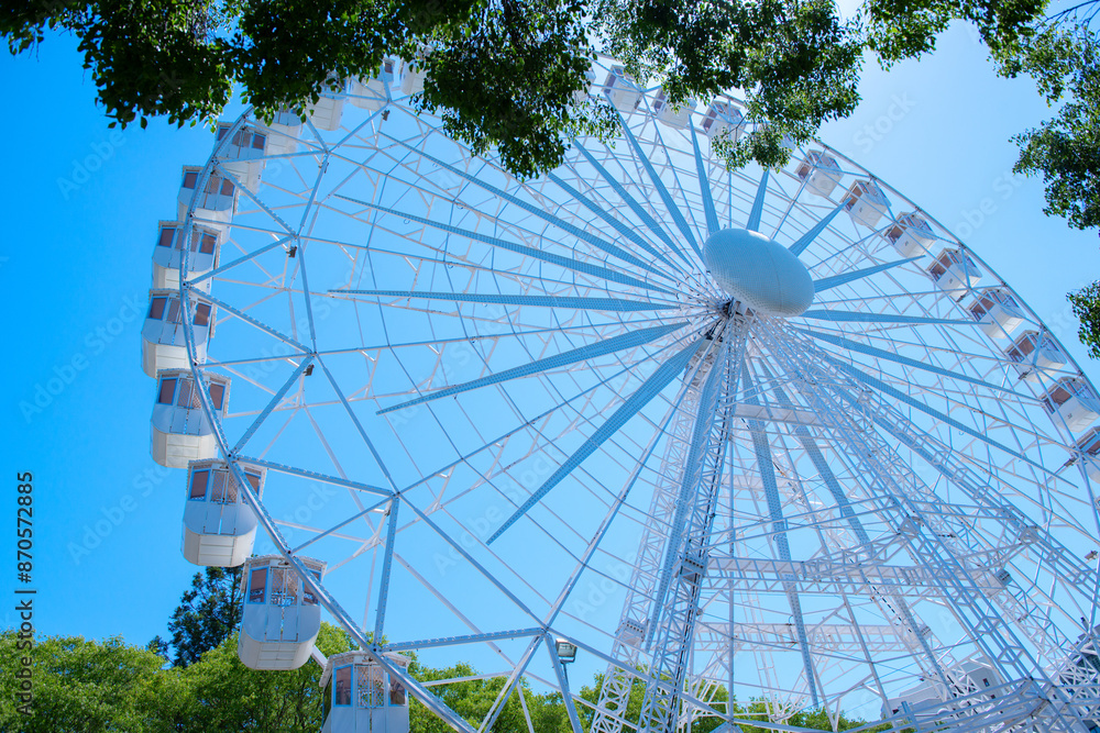 Ferris wheel in amusement park over blue sky Ferris wheel in amusement park over blue sky