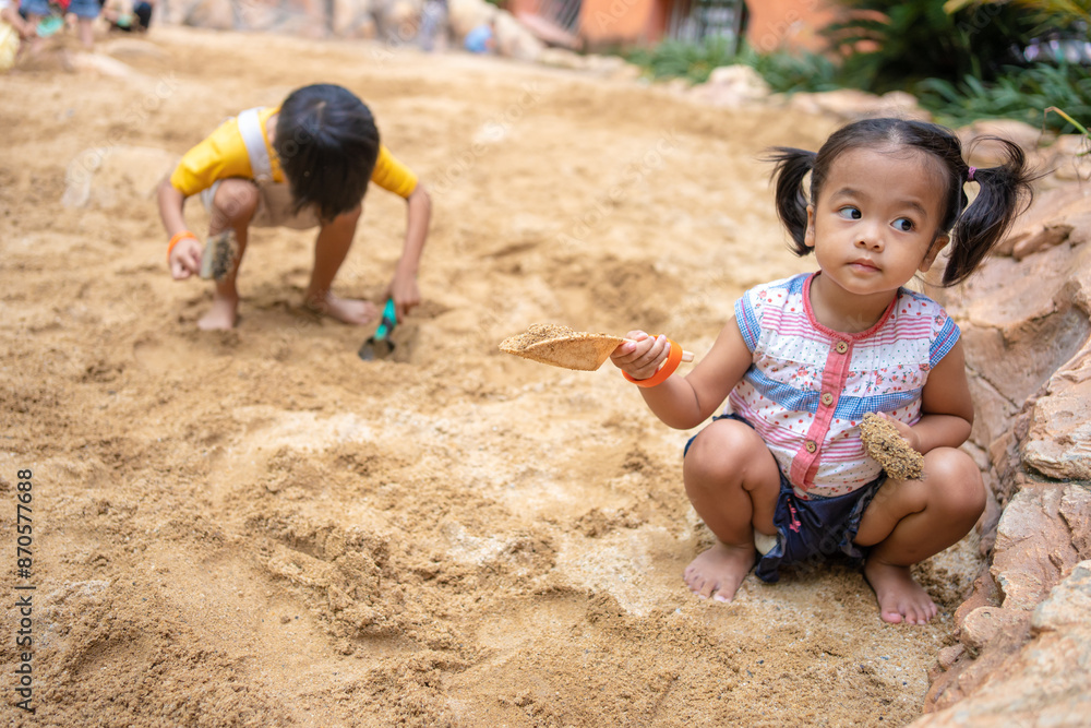 Asian kindergarten boy and girl enjoy playing in sandbox having fun on playground in sandpit. Asian kindergarten boy and girl enjoy playing in sandbox having fun on playground in sandpit.