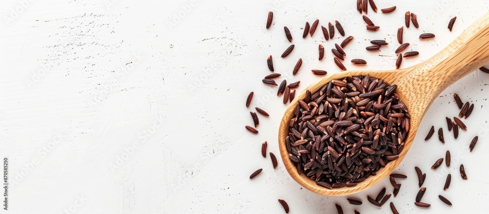 An overhead shot of organic rice berry in a wooden spoon on a white backdrop with ample copy space image. An overhead shot of organic rice berry in a wooden spoon on a white backdrop with ample copy space image.
