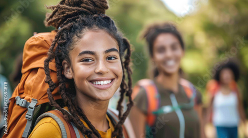 Smiling young hikers with backpacks on a nature trail, enjoying an outdoor adventure and fresh air. © tashechka