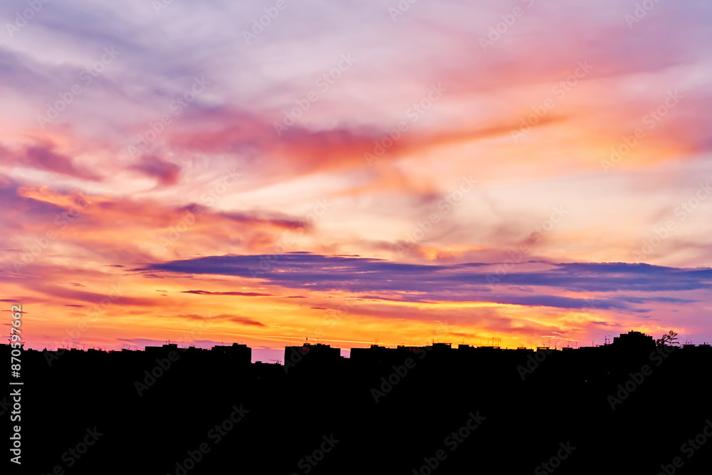 Dusk, sunset sky clouds in the evening with colorful orange, yellow, pink and red sunlight and dramatic storm clouds in the twilight sky, landscape horizon, nature, summer background. Dusk, sunset sky clouds in the evening with colorful orange, yellow, pink and red sunlight and dramatic storm clouds in the twilight sky, landscape horizon, nature, summer background.