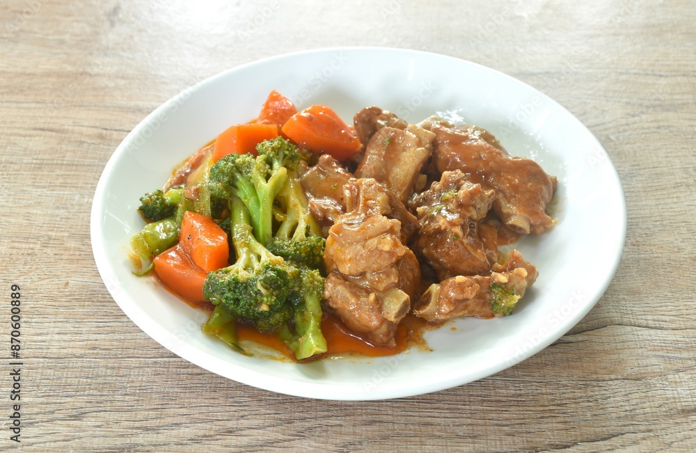 fried pork bone with steamed broccoli and carrot dressing sweet red gravy sauce on plate fried pork bone with steamed broccoli and carrot dressing sweet red gravy sauce on plate