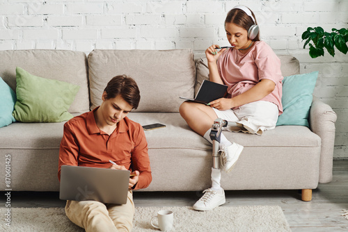 A couple spends time together, each working on their own tasks in a cozy living room. photo