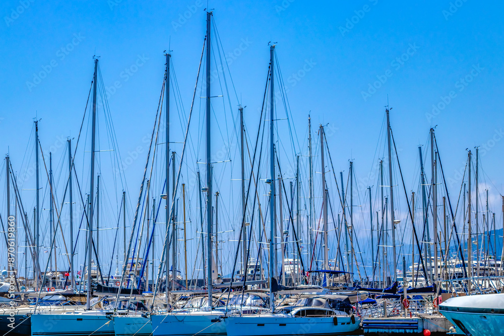 Fototapeta premium Marina with sailboats under blue sky, creating a peaceful setting for marine leisure