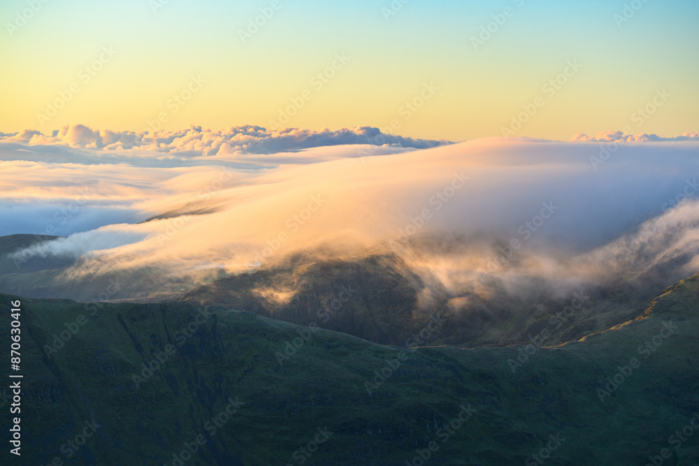 Obraz premium Clouds above the mountains on a beautiful sunny morning seen from Helvellyn in The Lake District, UK.