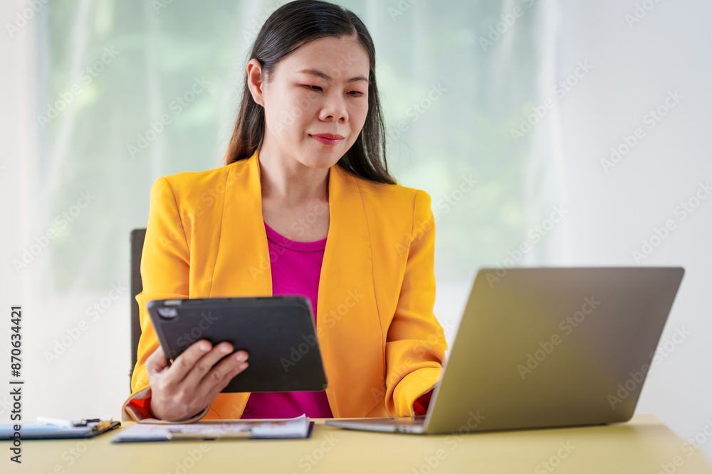 An Asian businesswoman is diligently working at an accountant's desk, surrounded by financial documents and a laptop, meticulously analyzing data to ensure accurate and efficient financial management. An Asian businesswoman is diligently working at an accountant's desk, surrounded by financial documents and a laptop, meticulously analyzing data to ensure accurate and efficient financial management.