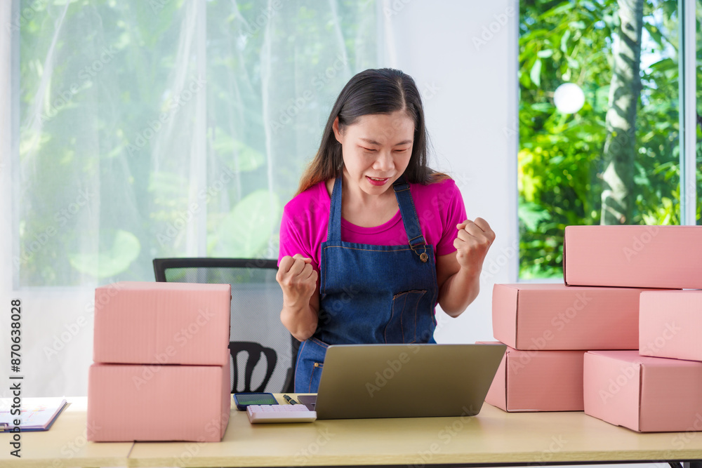 A woman in overalls sells products online, inspects parcels, takes customer orders, works at a desk, and uses pink boxes to pack items ready for shipping to customers. A woman in overalls sells products online, inspects parcels, takes customer orders, works at a desk, and uses pink boxes to pack items ready for shipping to customers.