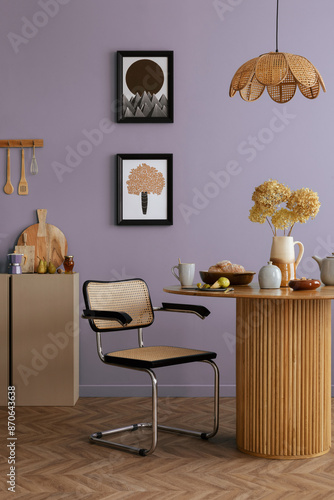 Warm and cozy dining room and kitchen interior with mock up poster frame, round table, rattan chair, beige commode, blue wall, vase with flowers and kitchen accessories. Home decor. Template.