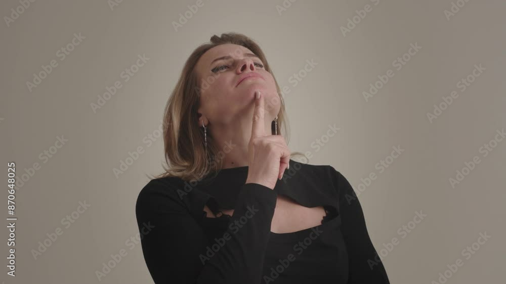 A thoughtful woman is deeply contemplating ideas with a serious expression on her face A thoughtful woman is deeply contemplating ideas with a serious expression on her face