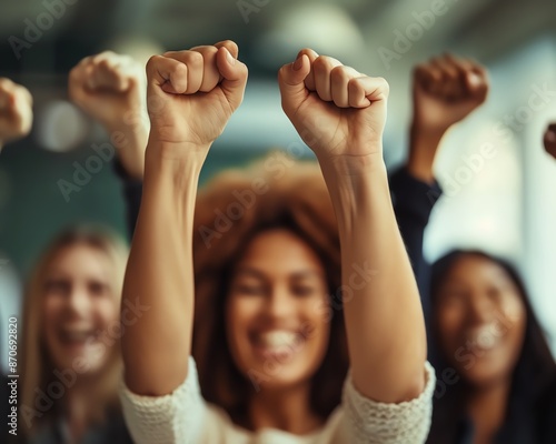 Group of diverse women celebrating success with raised fists.