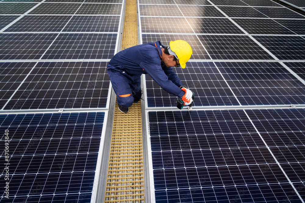A dedicated technician in safety gear inspects solar panels on a rooftop, verifying their alignment and cleanliness. professionals in green energy. A dedicated technician in safety gear inspects solar panels on a rooftop, verifying their alignment and cleanliness. professionals in green energy.