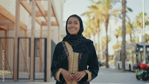 Cinematic image of a beautiful woman from Dubai wearing black abaya dress and walking in the city center and doing shopping.