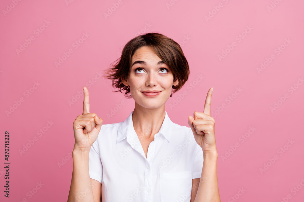 Portrait of nice girl with short hairstyle wear stylish blouse indicaitng look up at sale empty space isolated on pink color background Portrait of nice girl with short hairstyle wear stylish blouse indicaitng look up at sale empty space isolated on pink color background