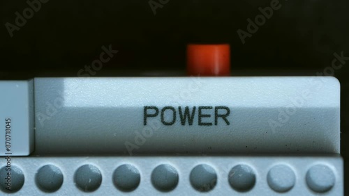 Man fingertip presses against power button activating device. Worker in process of turning on device or appliance with deliberate action