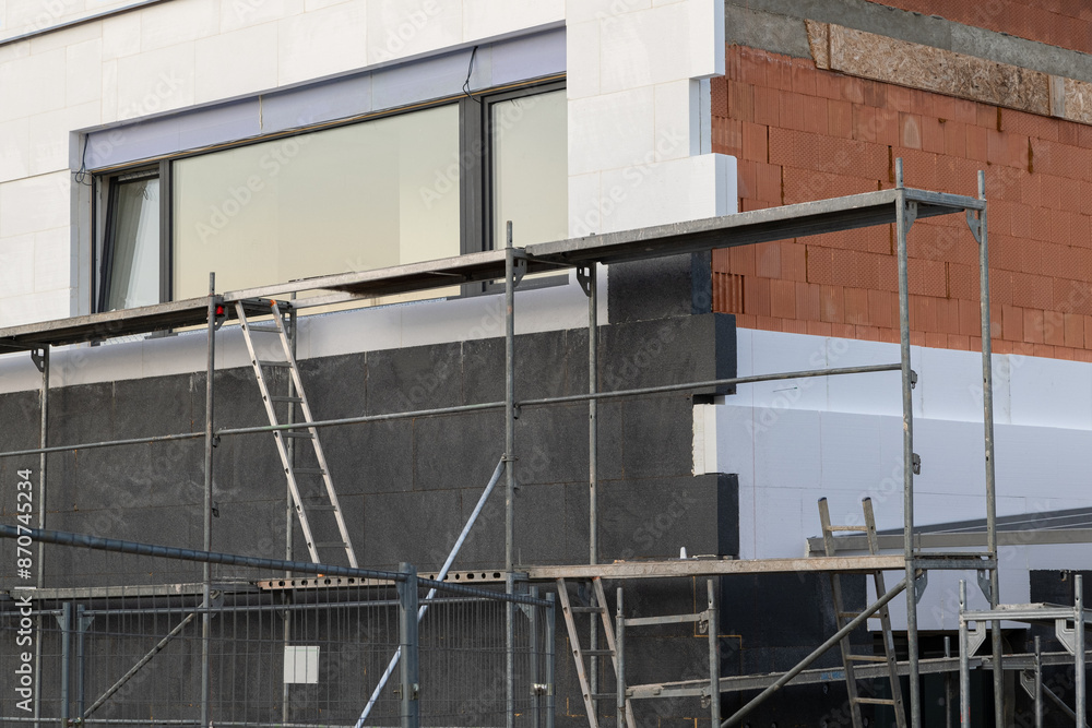 Naklejka premium insulating the walls with modern thermal insulation materials. The new house construction process involves Exterior covering is applied at the construction site.