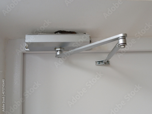 There is an automatic device on the door that prevents the door from slamming. Made of metal