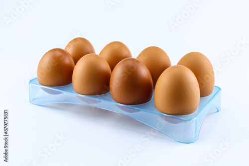 Chicken eggs in an egg holder on a white isolated background are suitable for photo illustrations photo