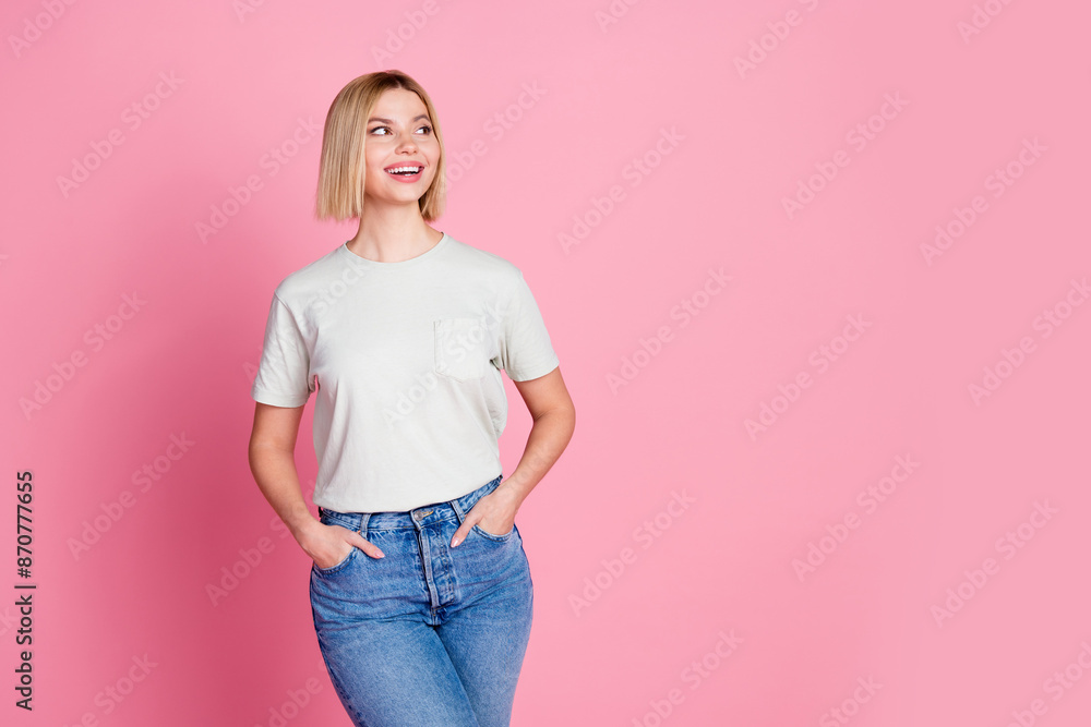 Portrait of optimistic girl with bob hair wear white t-shirt arms in pockets look at sale empty space isolated on pink color background Portrait of optimistic girl with bob hair wear white t-shirt arms in pockets look at sale empty space isolated on pink color background