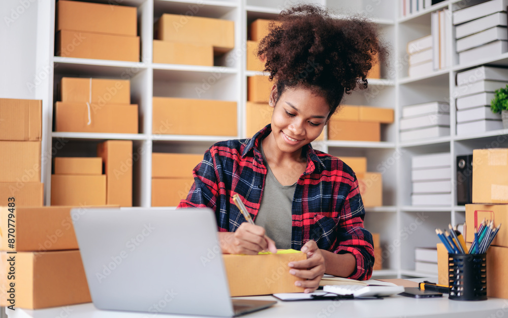 A woman is sitting at a desk with a laptop and a stack of boxes A woman is sitting at a desk with a laptop and a stack of boxes